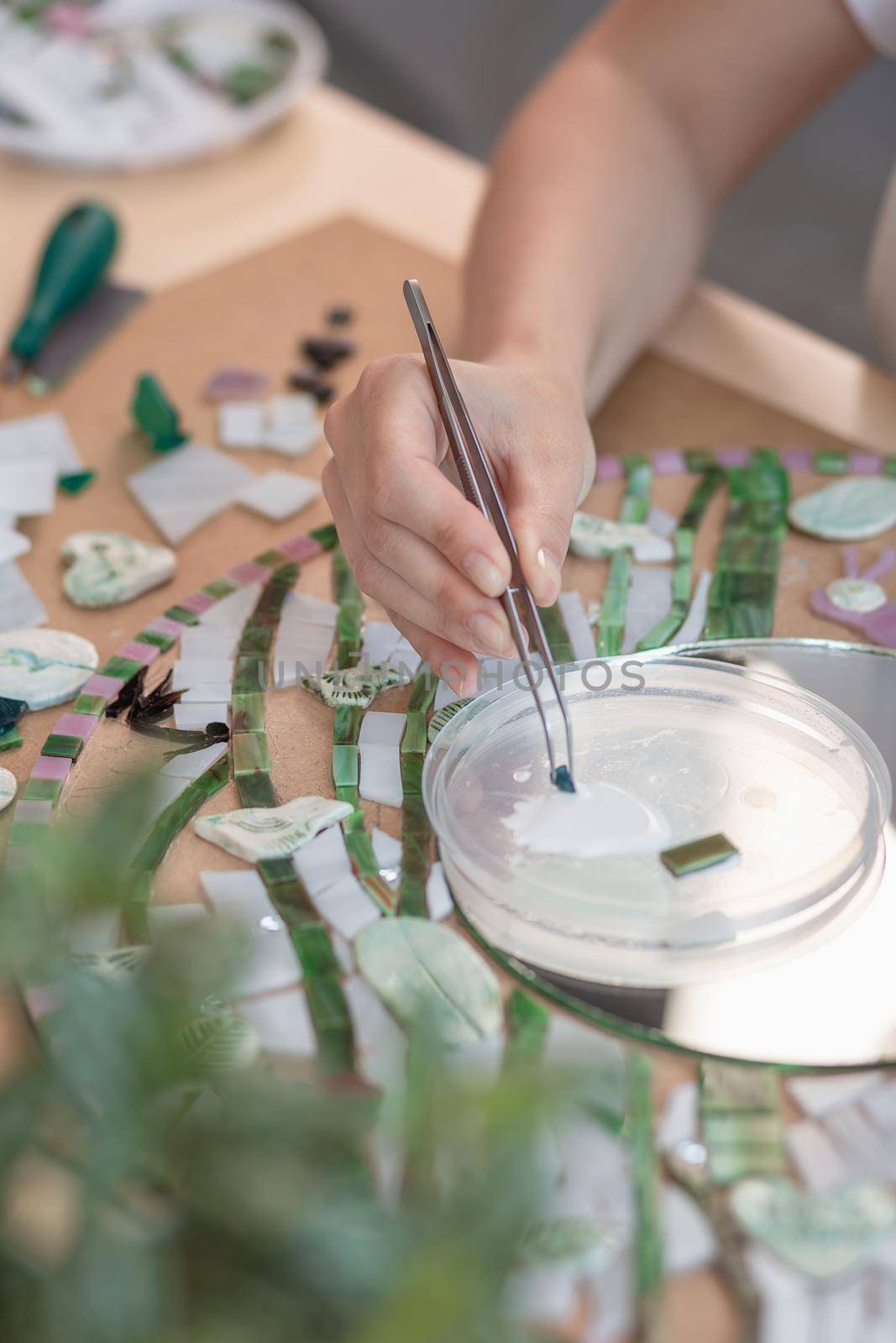 Hands of master working on new modern colorful mosaic. Close-up by nazarovsergey