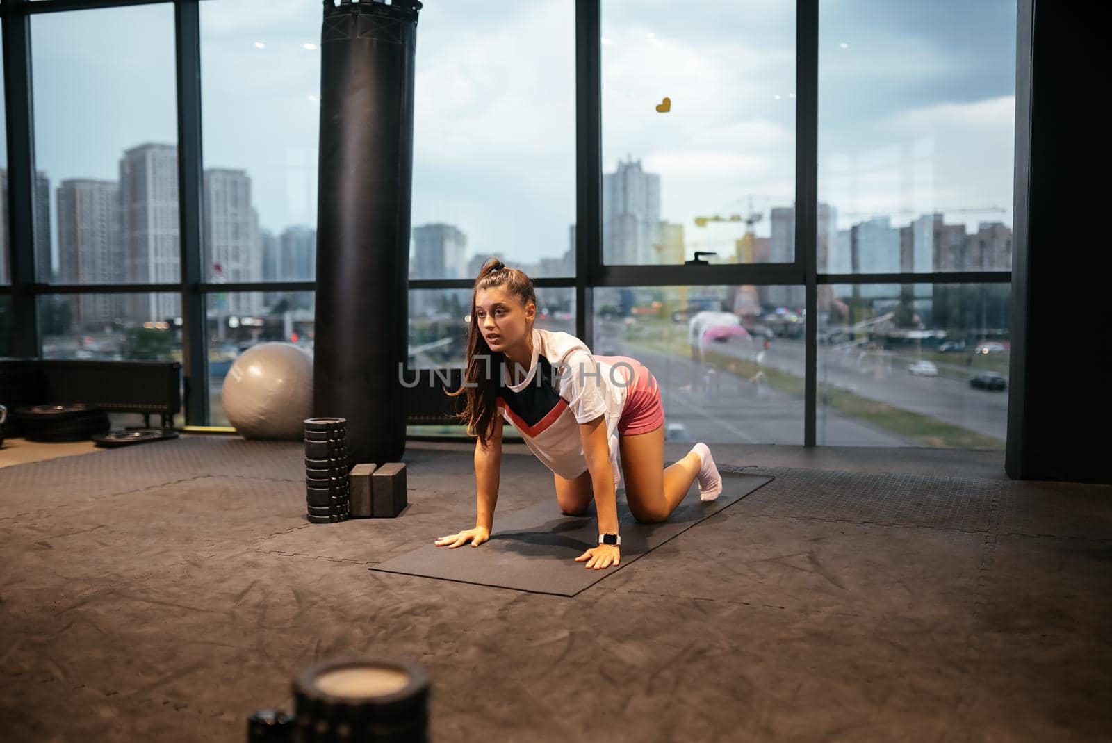 Young woman doing exercises in the gym during morning