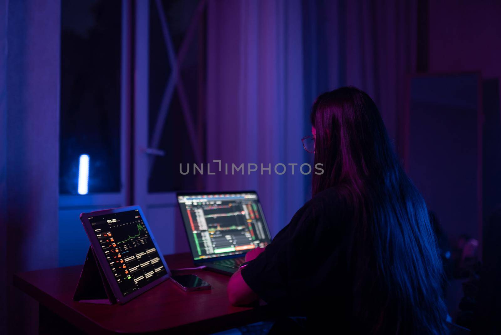 Attractive young woman working in home at night. Girl using laptop.