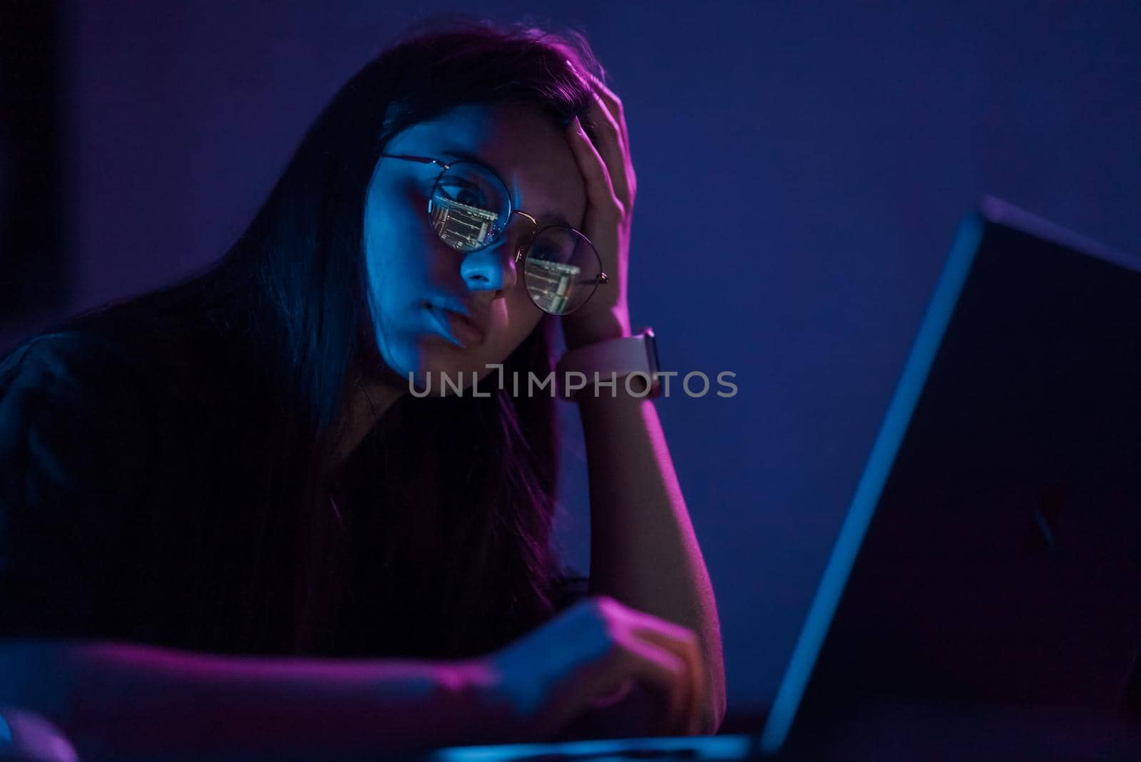 Attractive young woman working in home at night. Girl using laptop.