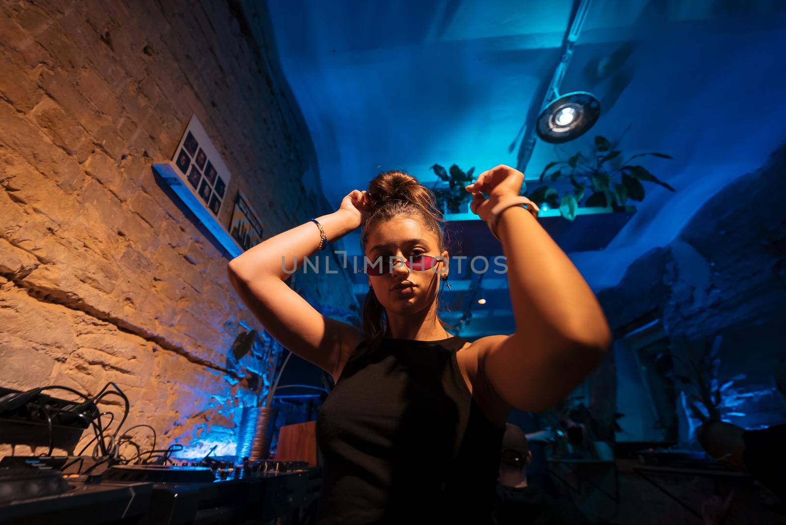 Beautiful female DJ dancing to techno