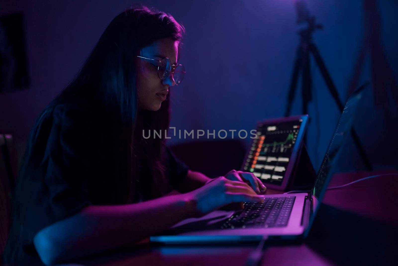 Attractive young woman working in home at night. Girl using laptop.
