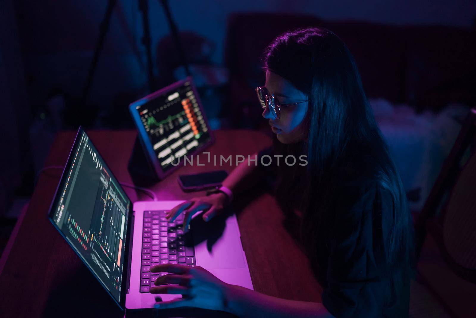 Attractive young woman working in home at night. Girl using laptop.