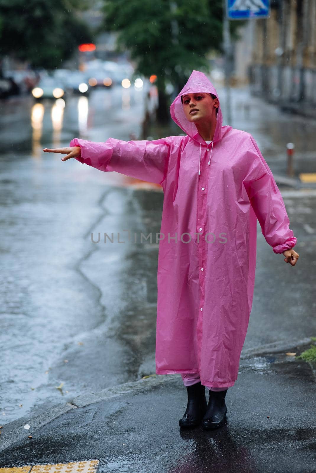 Woman catching taxi. Young girl trying to stop a cab. Woman calling a taxi on a rainy day.