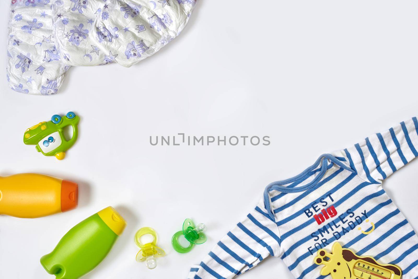 Baby care accessories and clothing on white background, top view. Flat lay. Copy space