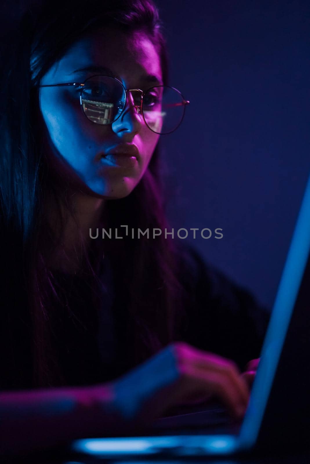 Attractive young woman working in home at night. Girl using laptop.