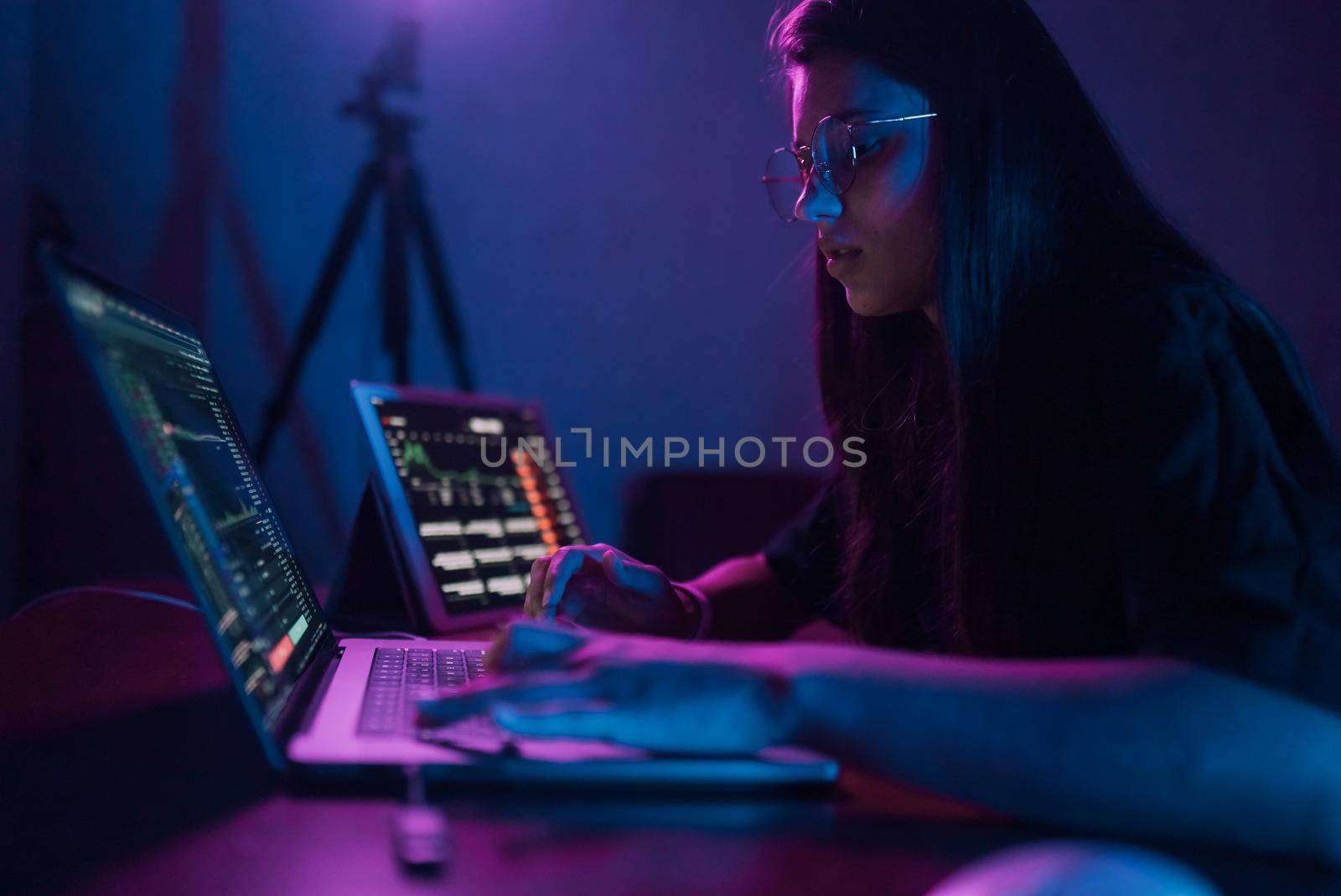Attractive young woman working in home at night. Girl using laptop.