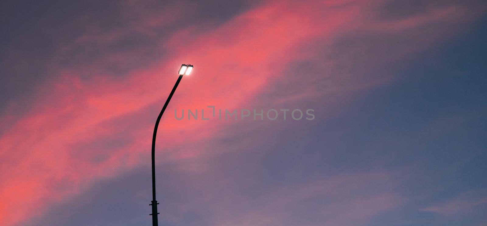 Lamppost at sunset . Sunset time. Copy space. An article about electricity. An article about pillars.