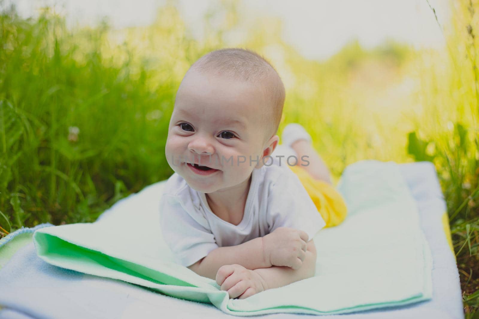 The baby is lying in the grass . A child in nature. Children's article. Copy Space