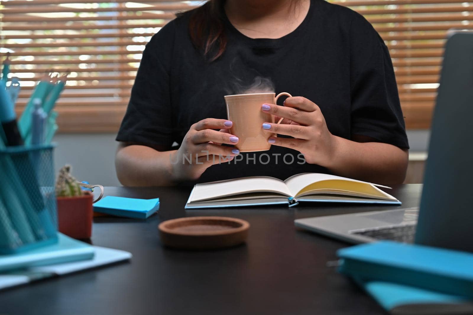 Young woman hands holding hot cup of coffee or tea.