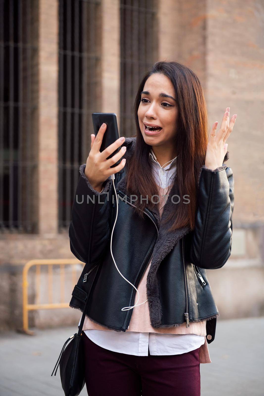 vertical photo of a scared woman watching her telephone, concept of technology and communication