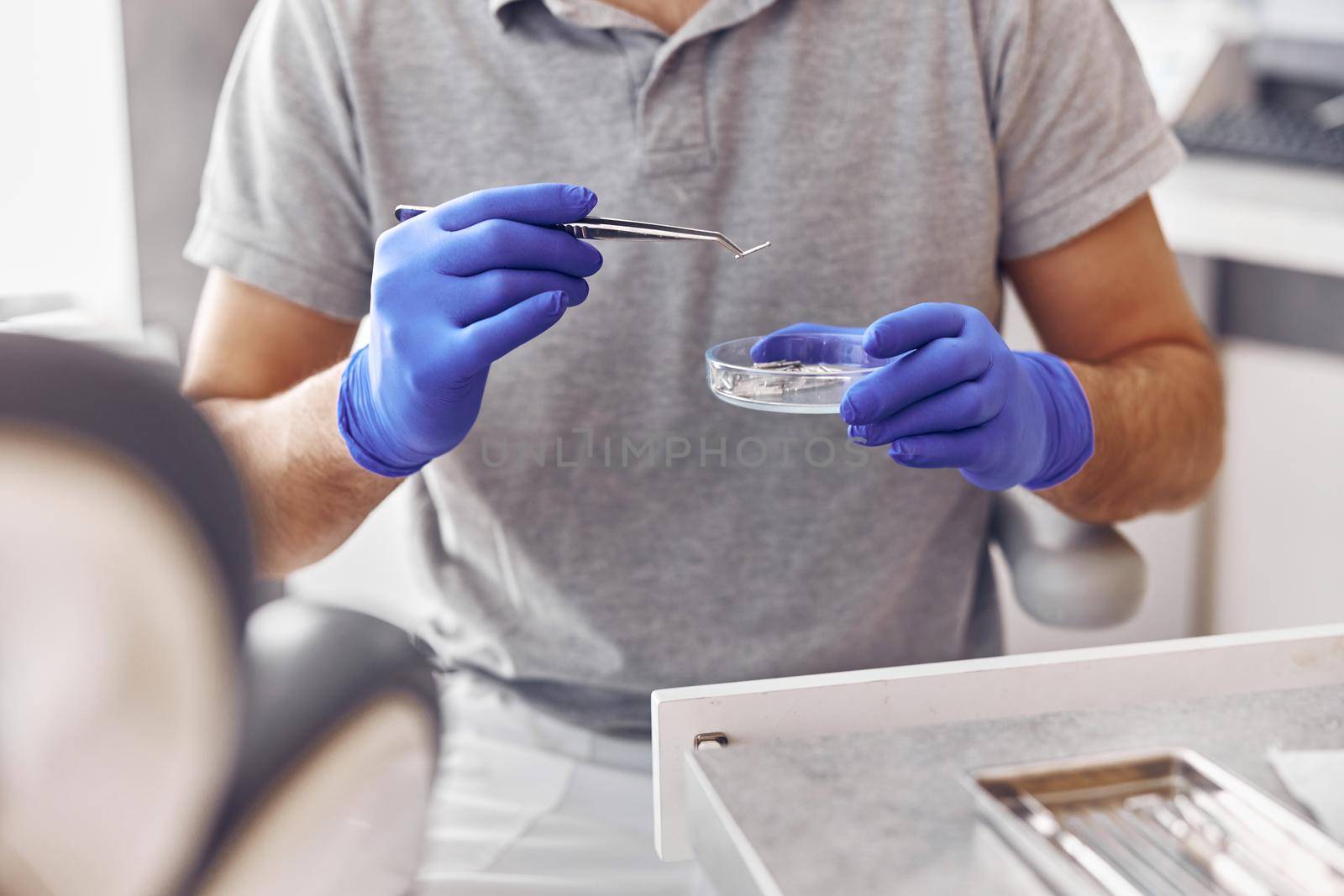 dentist is taking a drill in modern light stamotology clinic