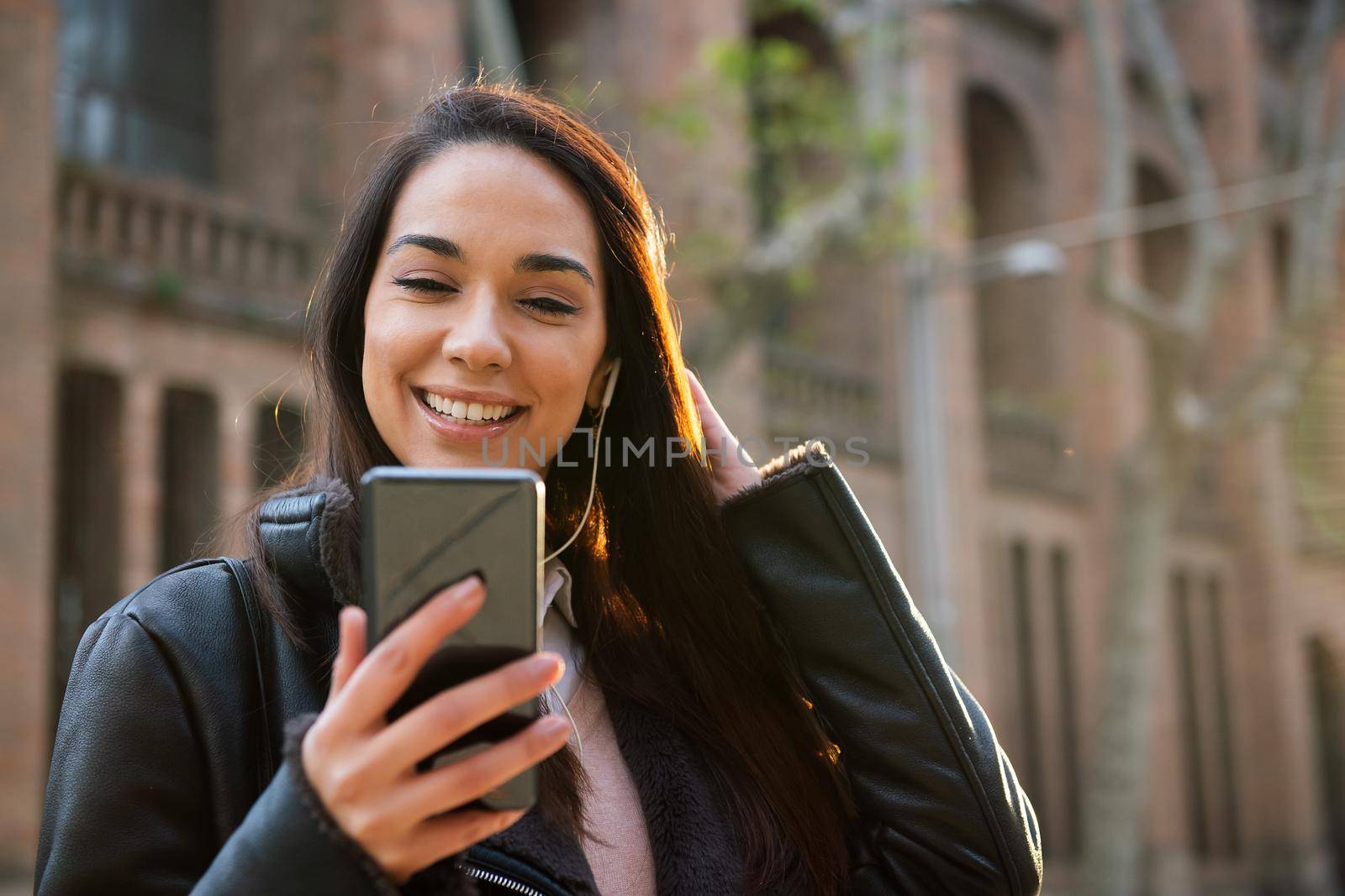 happy young woman reading a message at her phone by raulmelldo