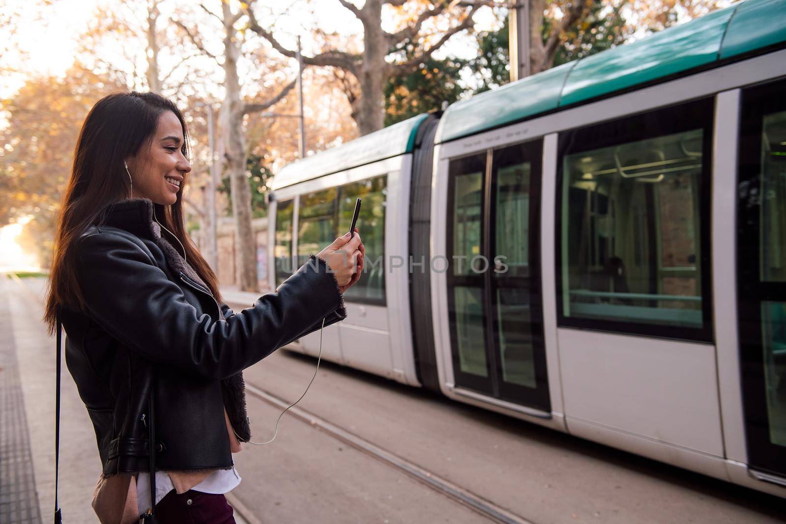 woman making video call with phone at the street by raulmelldo