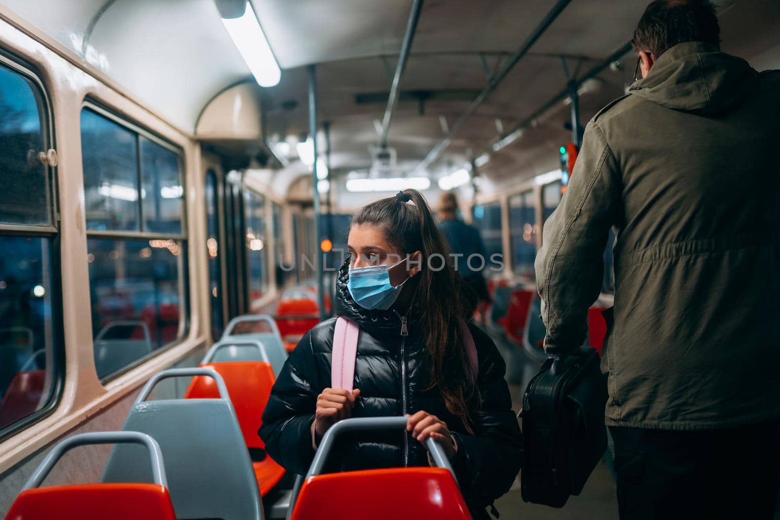 Young woman with mask traveling in the public transport by bus. Unique protective mask of the respiratory tract from coronavirus.