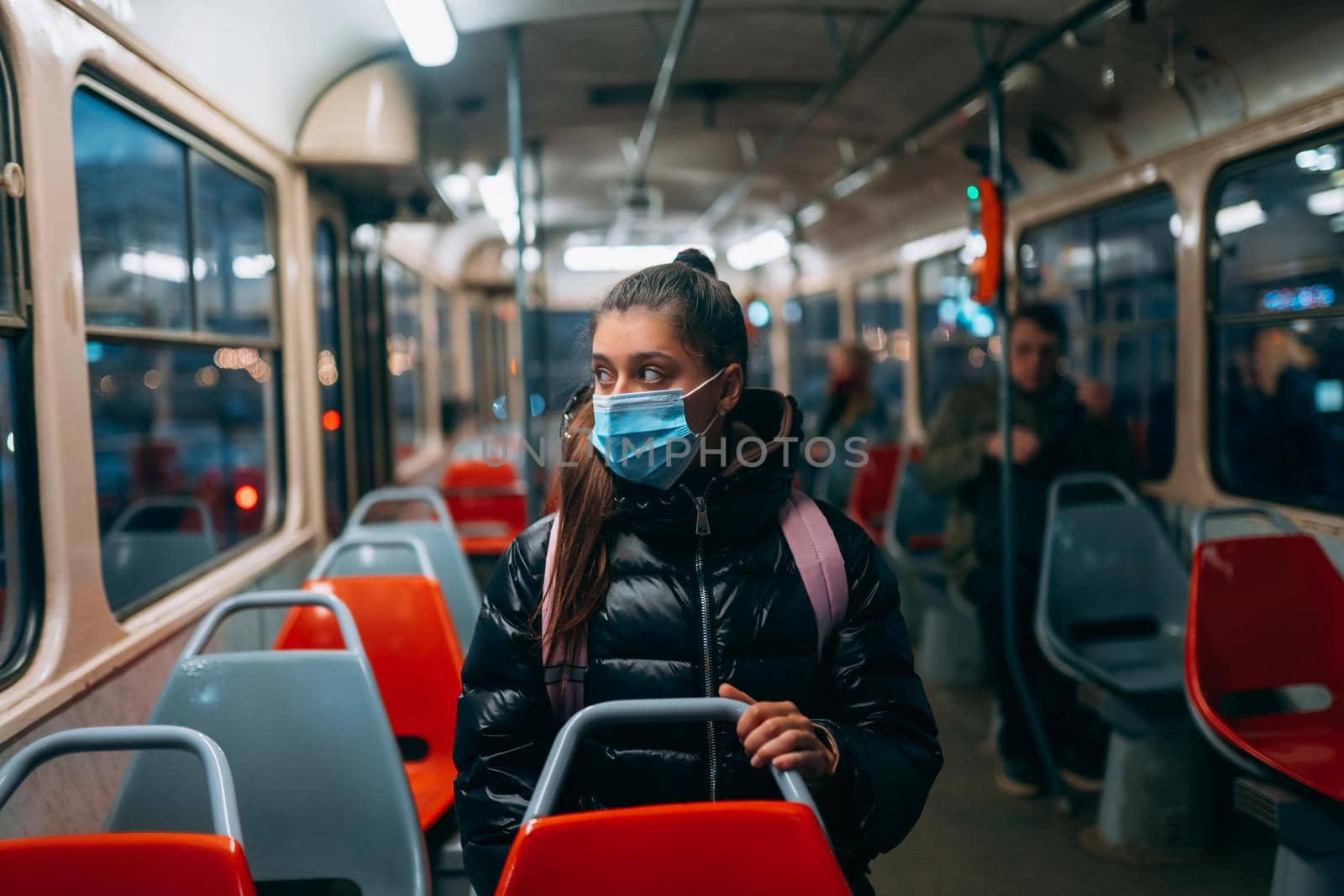 Young woman with mask traveling in the public transport by bus. Unique protective mask of the respiratory tract from coronavirus.