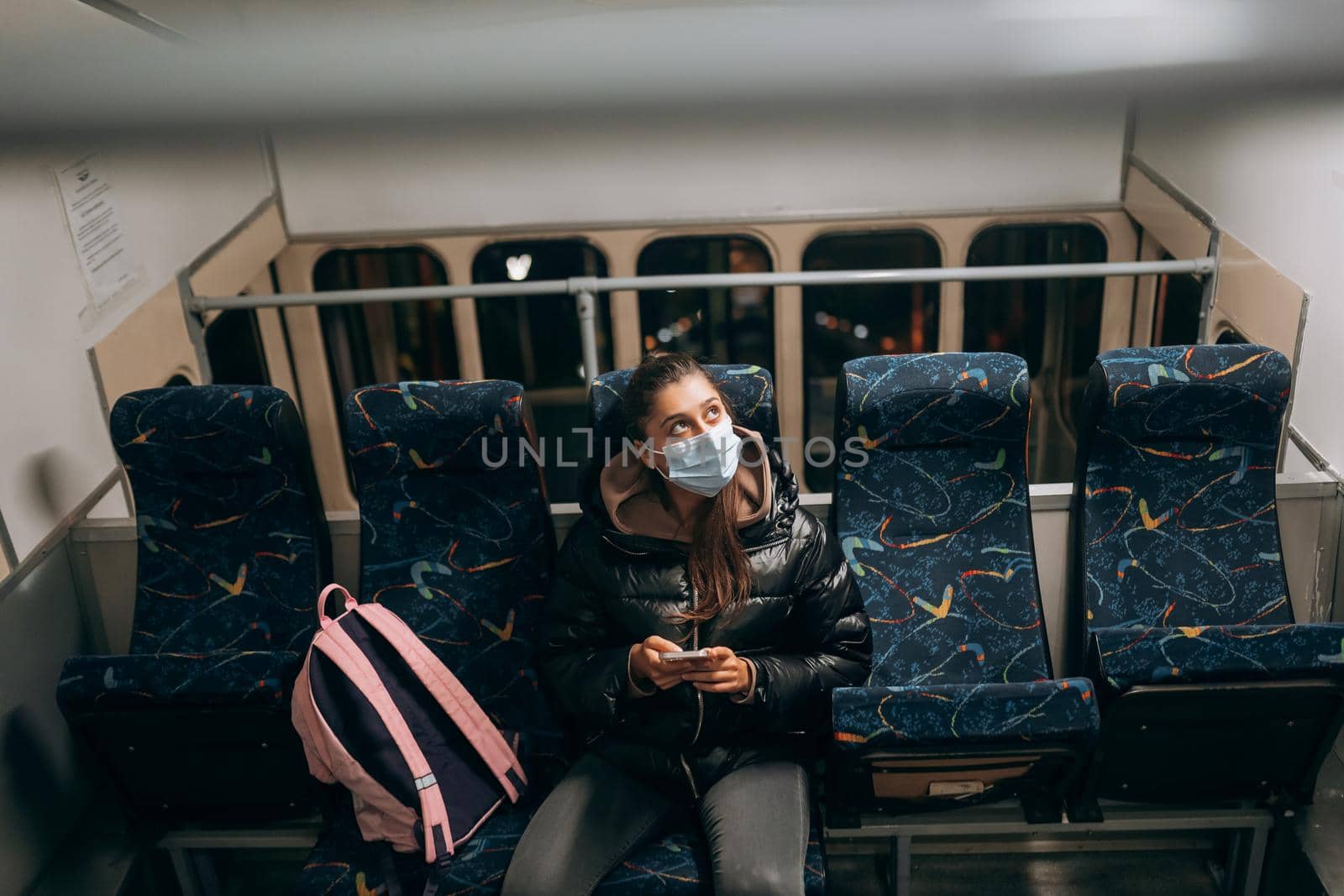 Young woman with mask traveling in the public transport by bus. Unique protective mask of the respiratory tract from coronavirus.