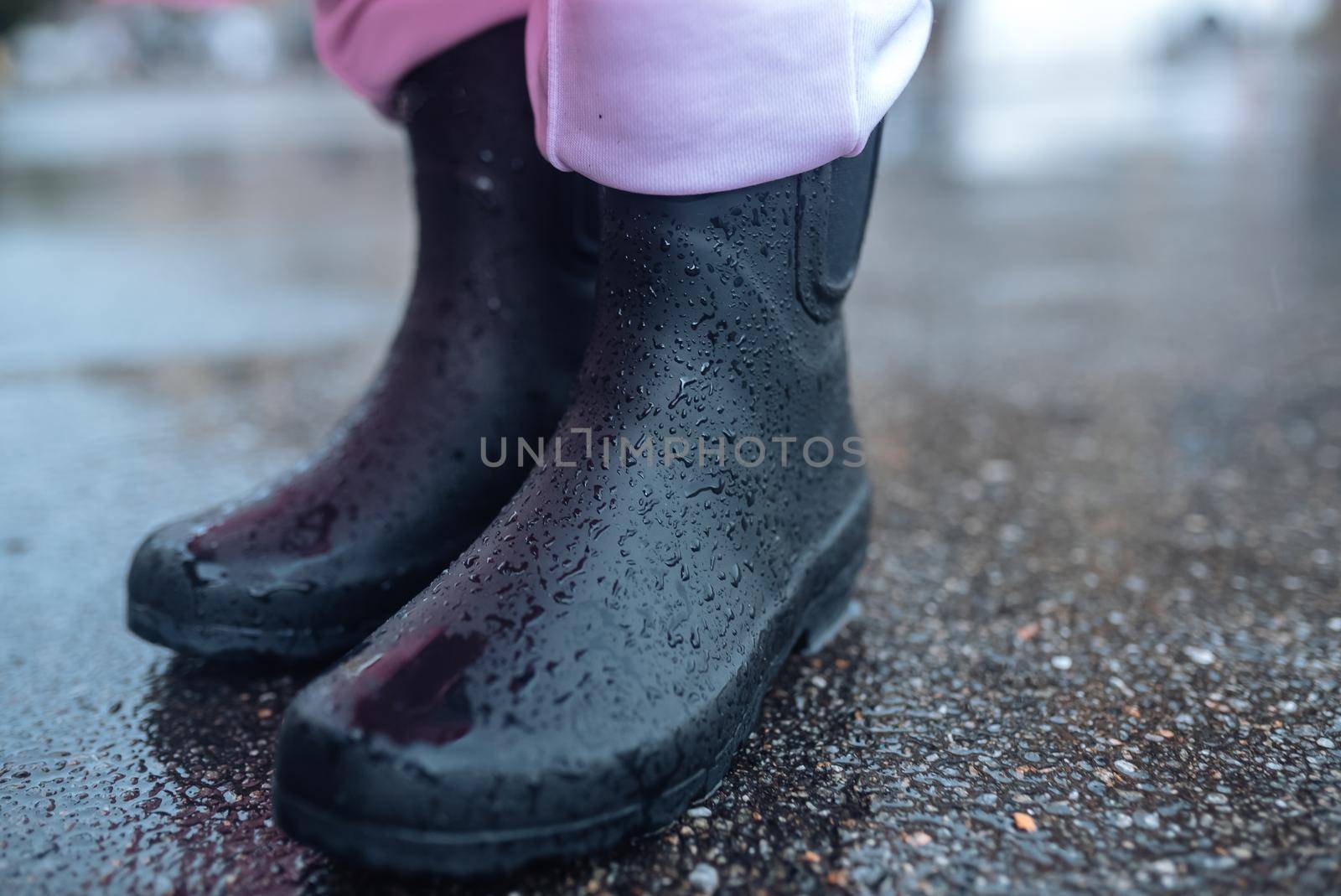 Young smiling woman with a pink raincoat on the street