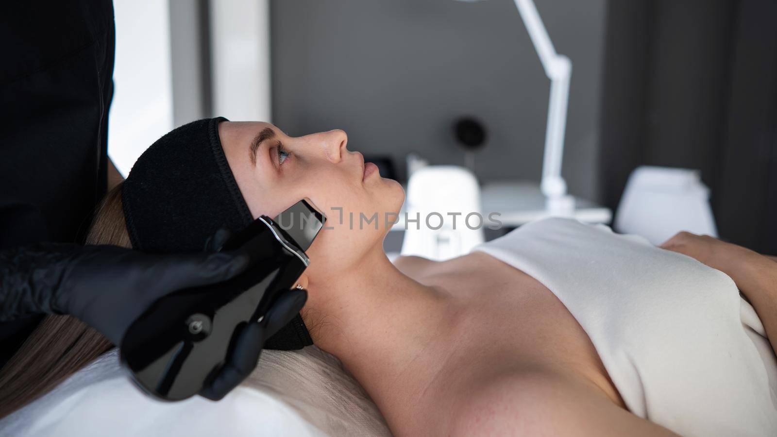 Woman on ultrasonic cleaning procedure. Hardware cosmetology