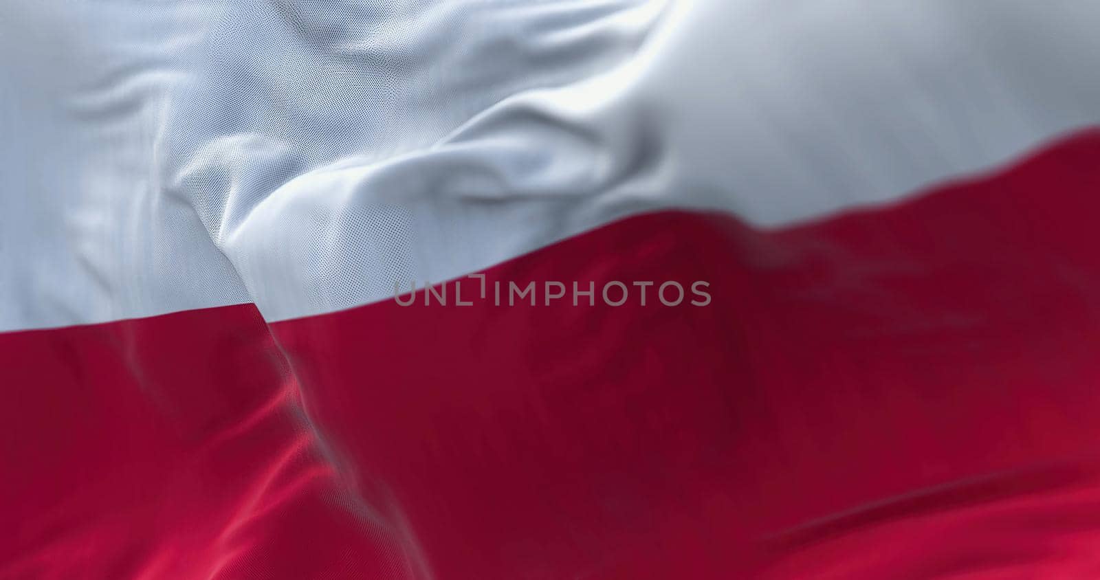 Close-up view of the Poland national flag waving in the wind. Poland is a country in Central Europe. Fabric textured background. Selective focus