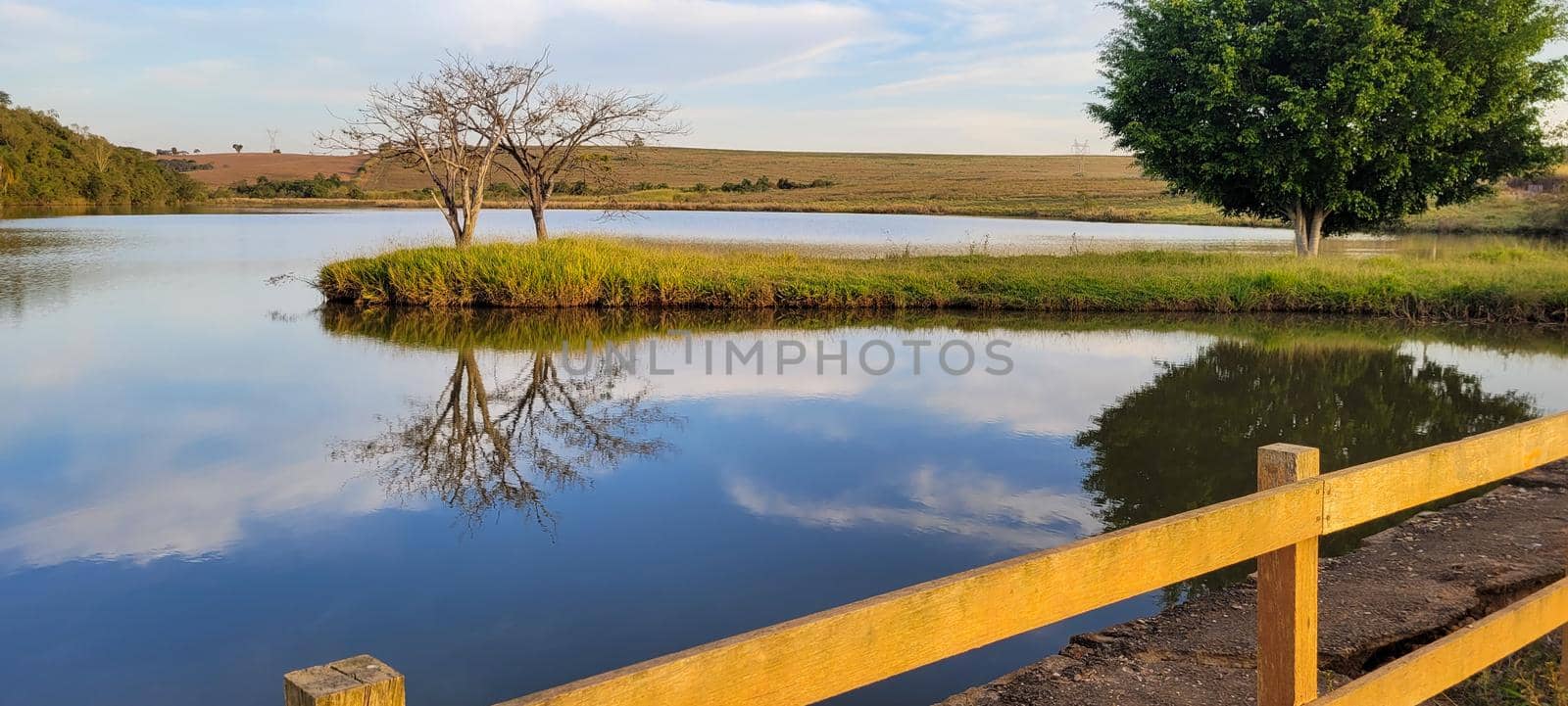 lake with a natural landscape of a farm in the countryside of Brazil with trees and lawn around it