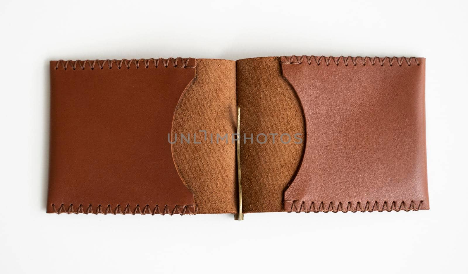 Open orange men's money clip genuine handmade leather wallet for cards lies on a white table. Leather goods and accessory