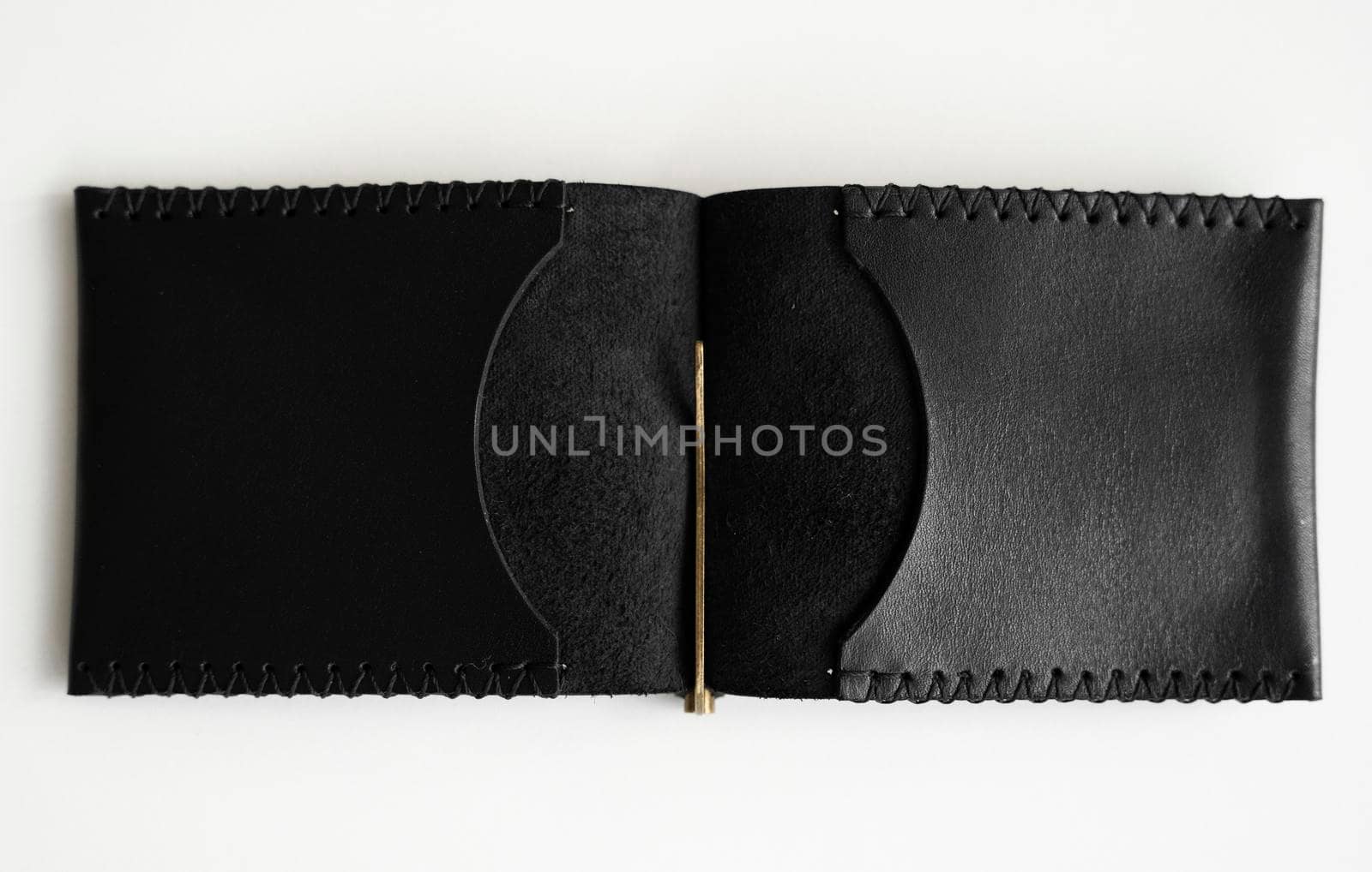 Open black men's money clip handmade leather wallet for cards lies on a white table. Leather goods and accessory