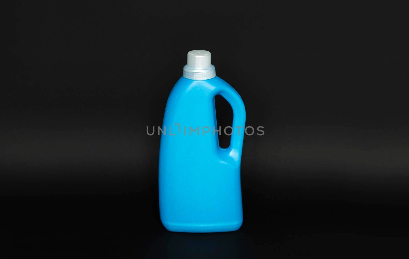 Blue plastic bottle with a grey cap isolated on black background for liquid detergent laundry or cleaning agent. Packaging template mockup