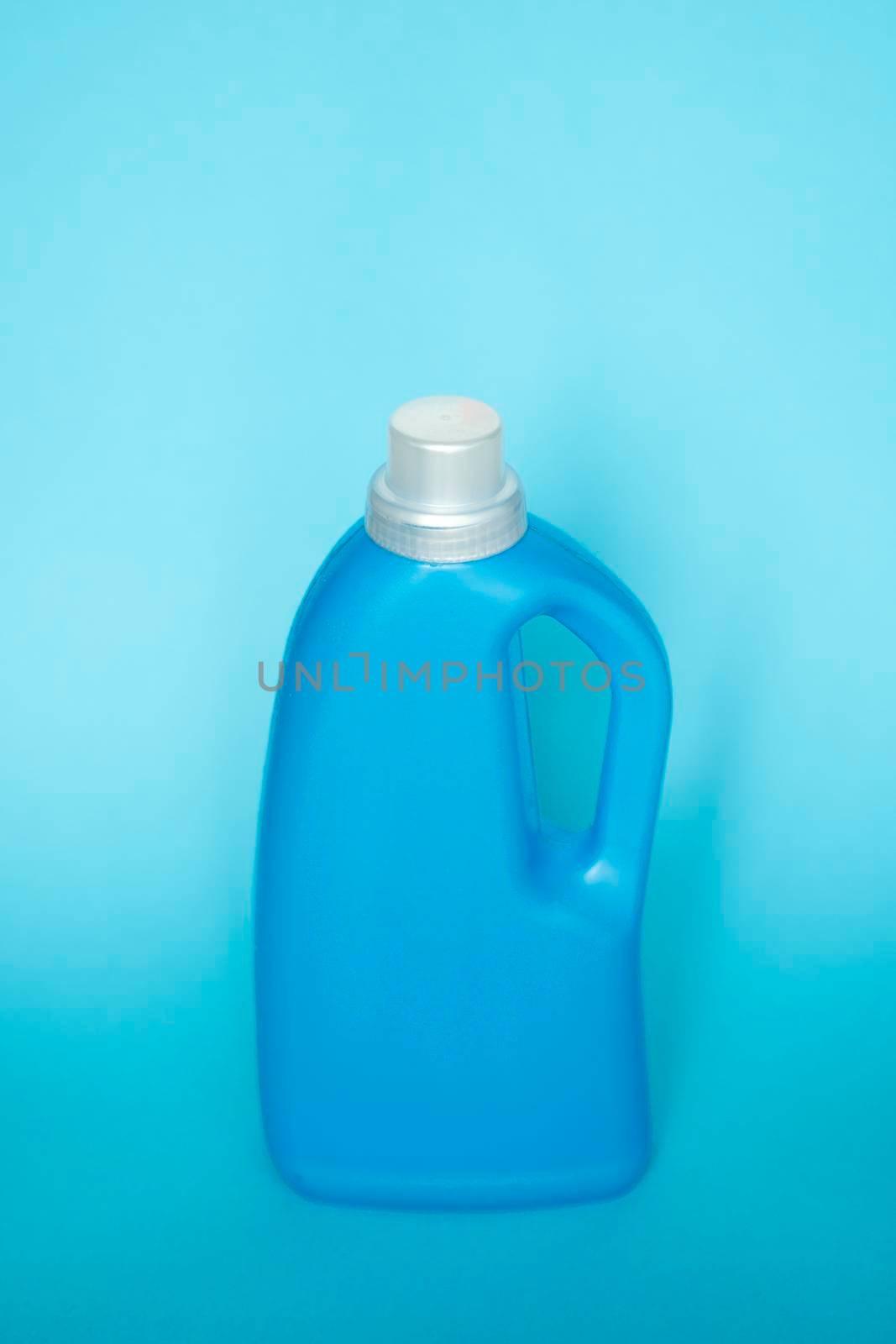Blue plastic bottle with a grey cap isolated on blue background for liquid detergent laundry or cleaning agent. Packaging template mockup