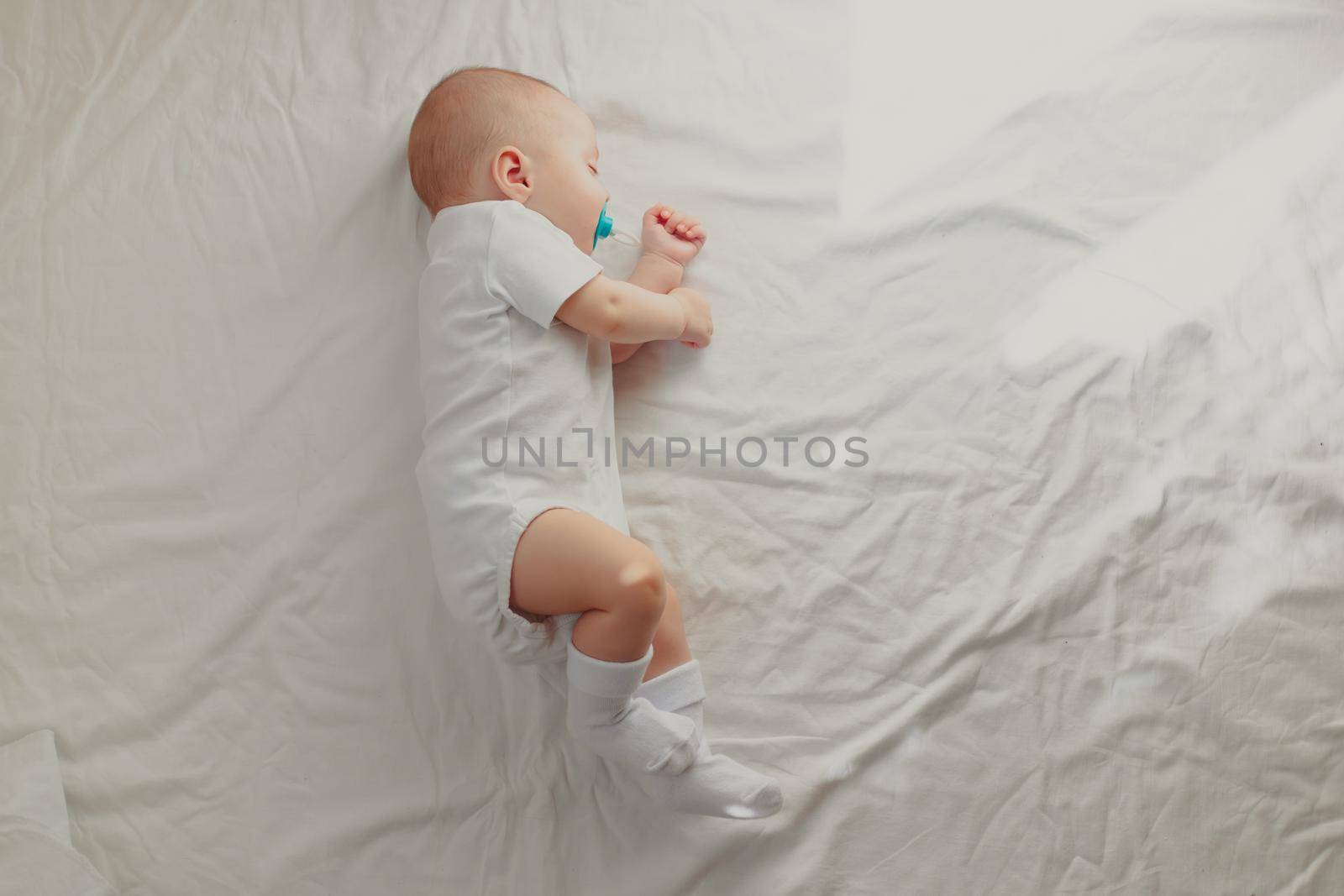 The baby is sleeping in his crib. Happy baby dream. A happy child. Children's article. Copy Space