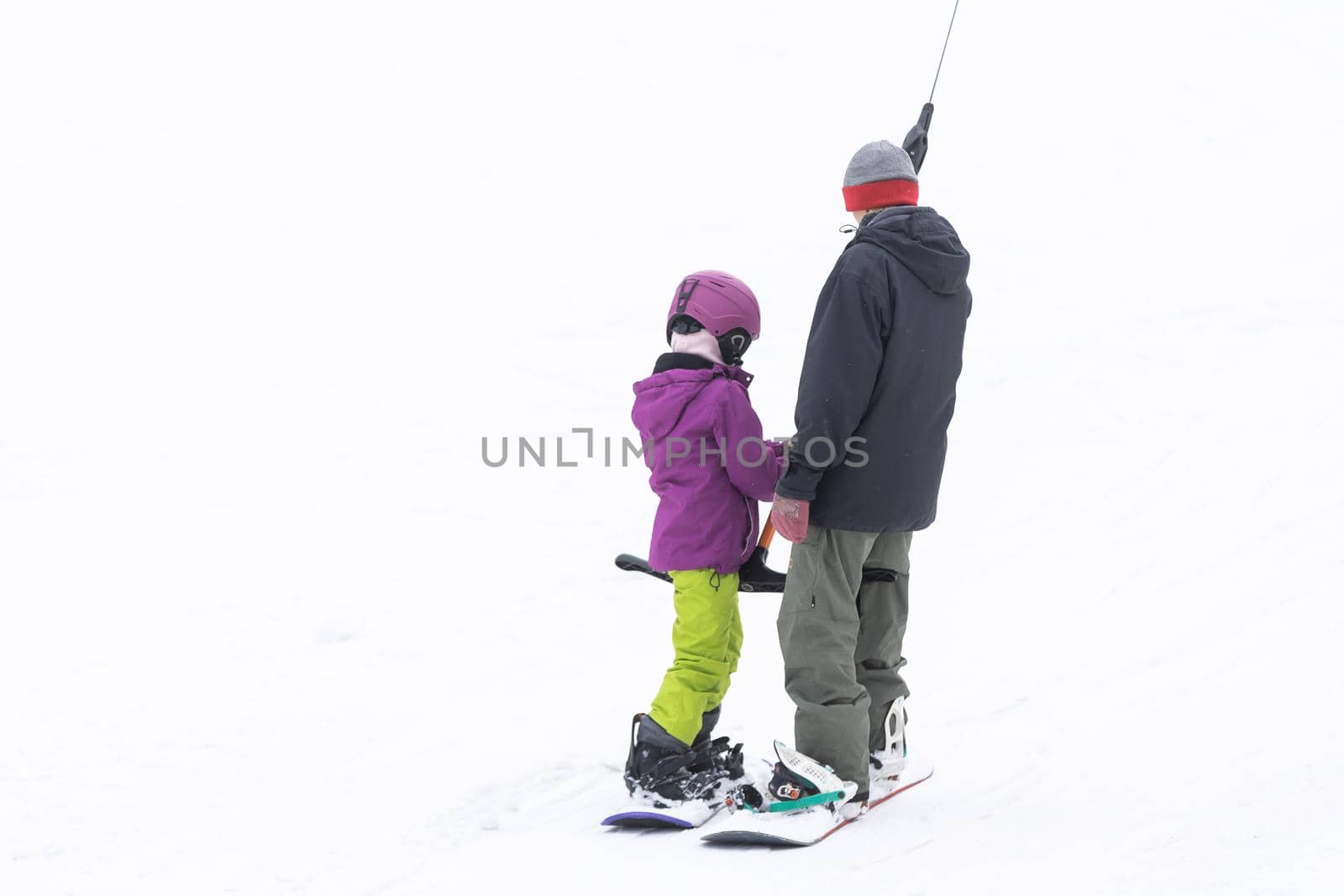 Ski Resort Father Teaching Little Daughter Snowboarding.
