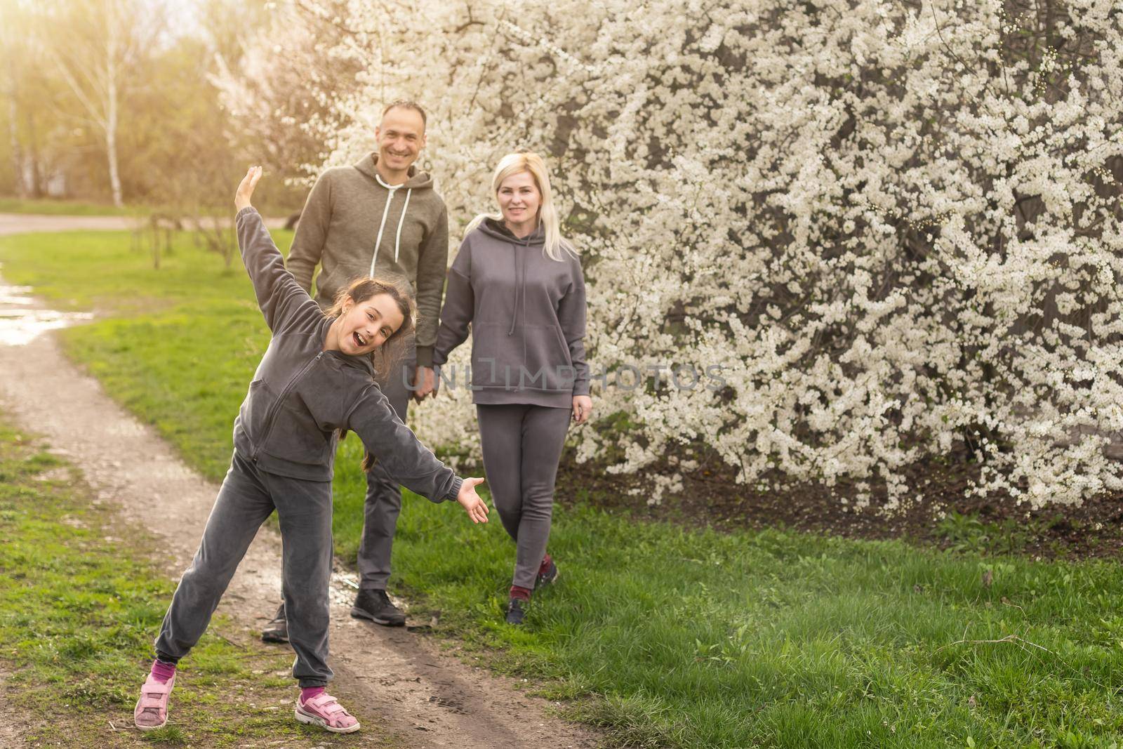 family in blossom garden with trees. by Andelov13