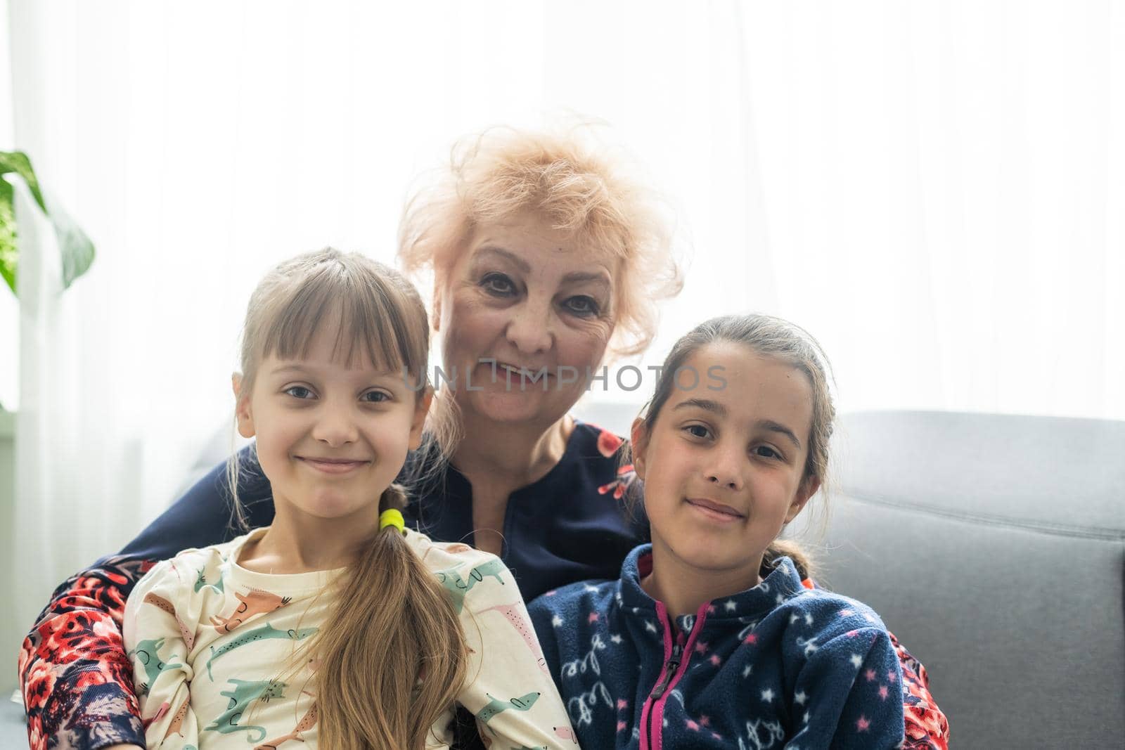 Smiling loving mature grandmother and two granddaughters.