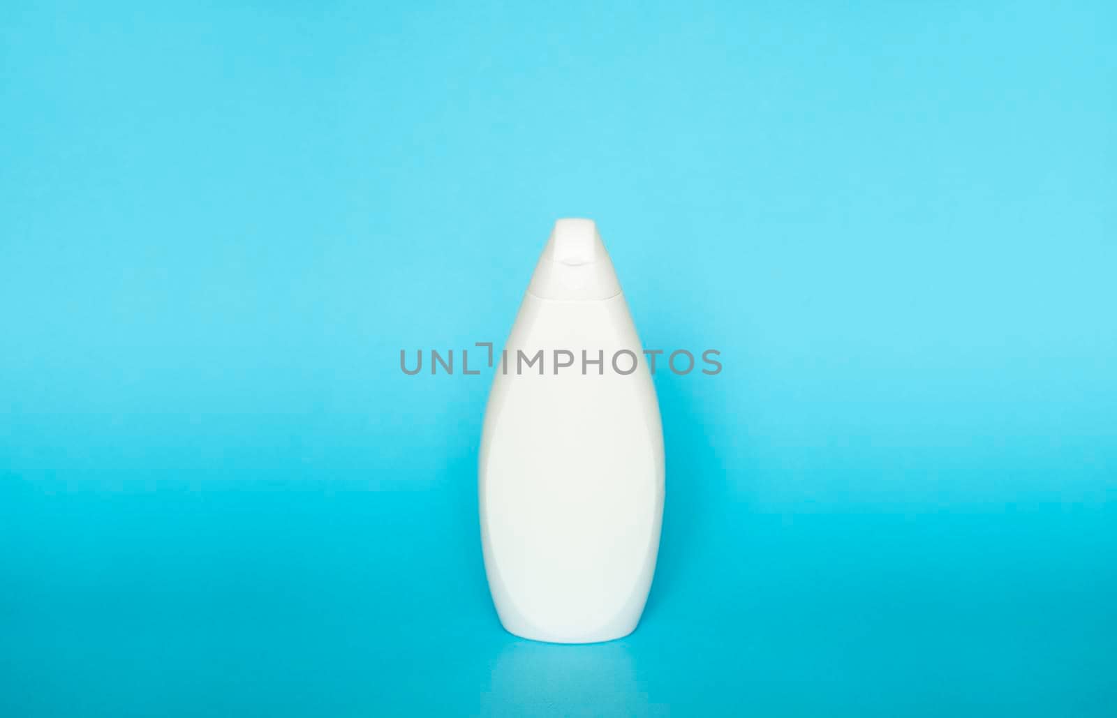 White plastic soap or shampoo bottle isolated on blue background. Skin care lotion. Bathing essential product. Shampoo bottle. Bath and body lotion. Fine liquid hand wash. Bathroom accessories