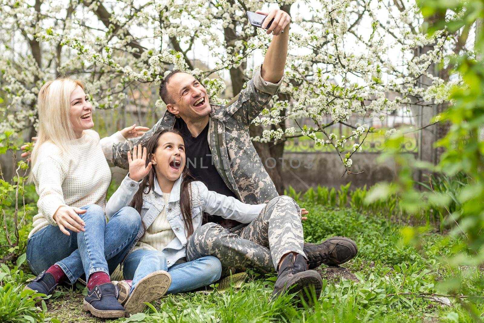 Soldier reunited with his family in park. by Andelov13