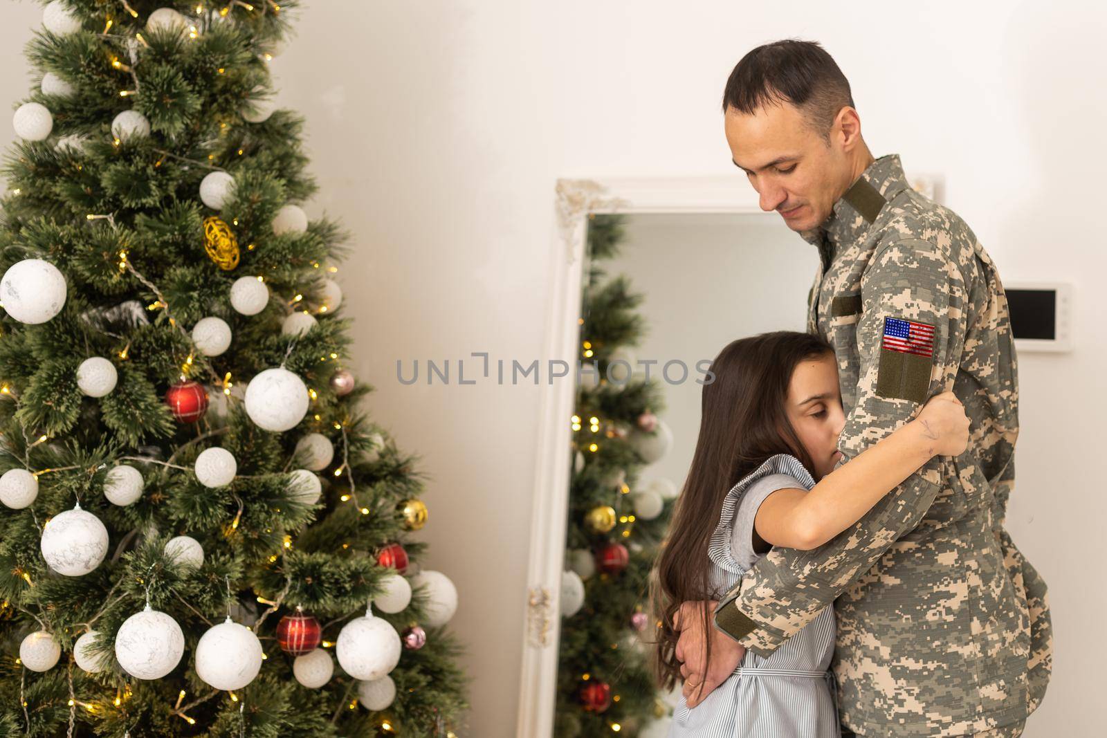 Soldier in uniform with his daughter. An off duty military man spending Christmas holiday with his family at home
