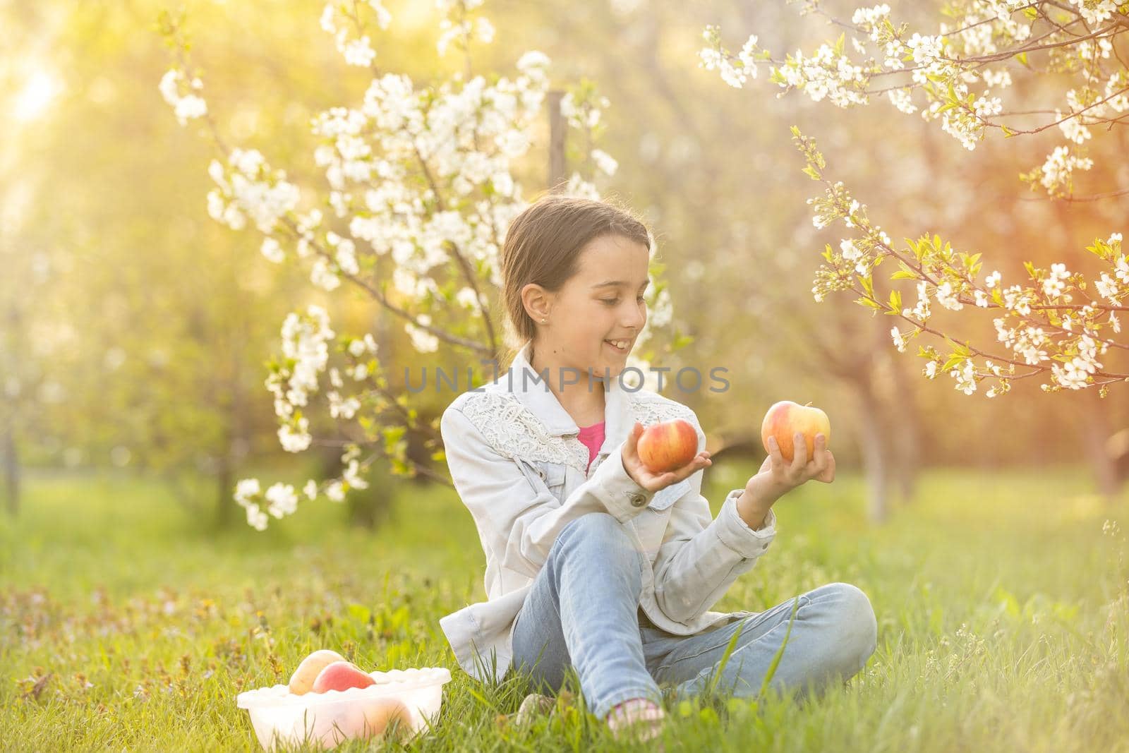Beautiful preteen girl enjoy spring apple blooming. Little preschool girl in garden tree flowers. Springtime. by Andelov13