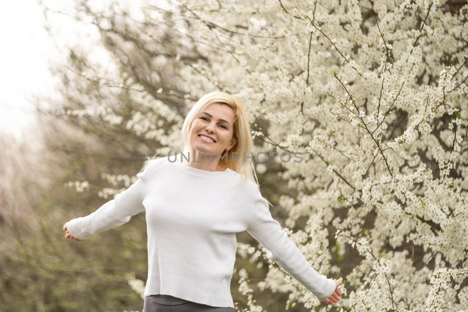 beautiful young woman in blooming cherry blossoms garden