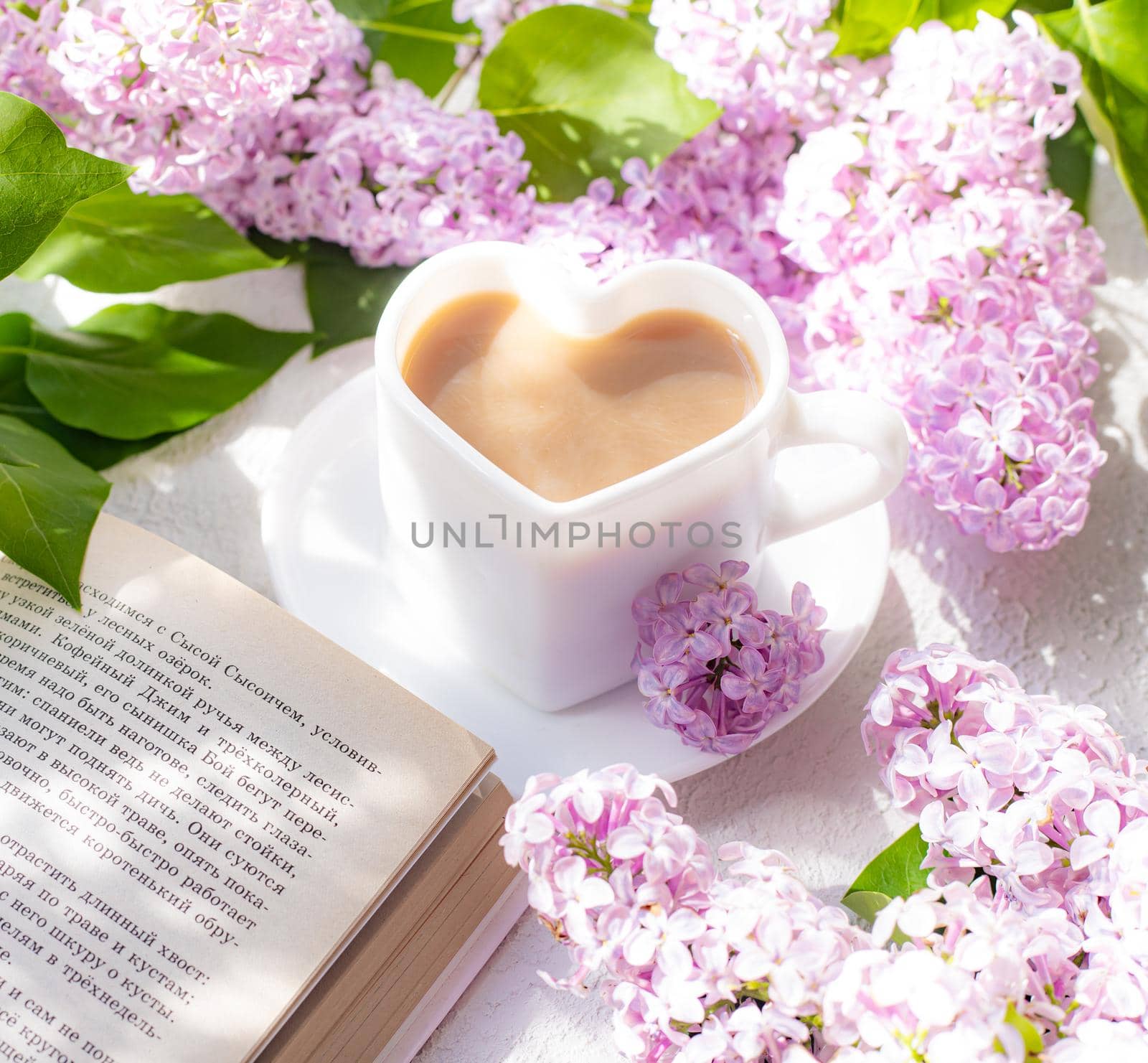 Cappuccino coffee in a cup and a branch of lilac on a white background with shadows . A hot drink. relax. The concept of cafeteria advertising. Article about cappuccino. Making cappuccino. Lilac branches. Copy space by alenka2194