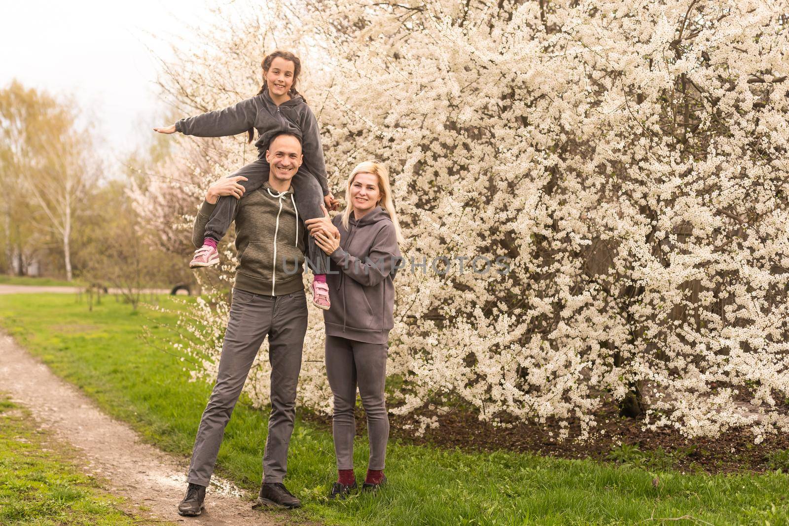 family in blooming garden with trees