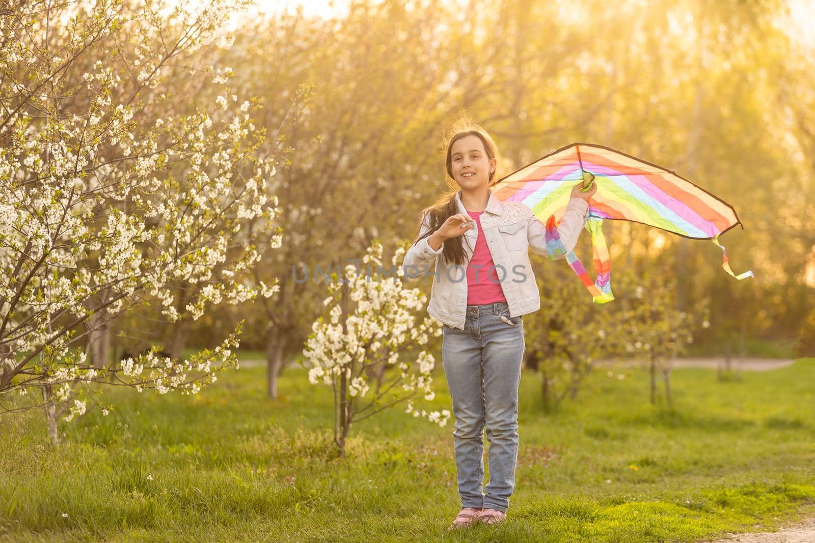 Happy child playing with colorful kite outdoors. Kid having fun in green spring field. Freedom and imagination concept by Andelov13