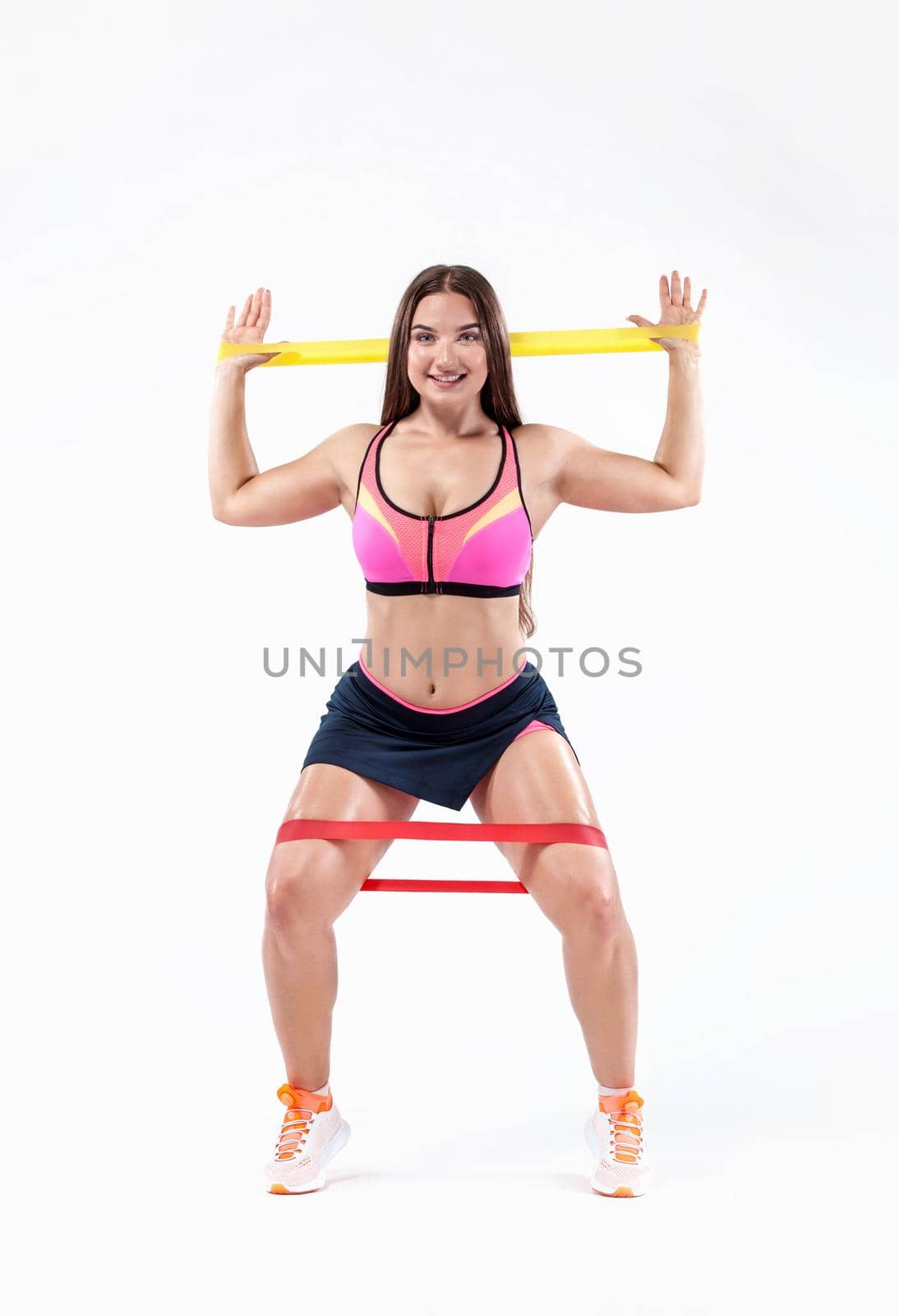 Size plus fitness woman athlete and bodybuilder holding expander or mini bands. Sport concept isolated on white background. by MikeOrlov