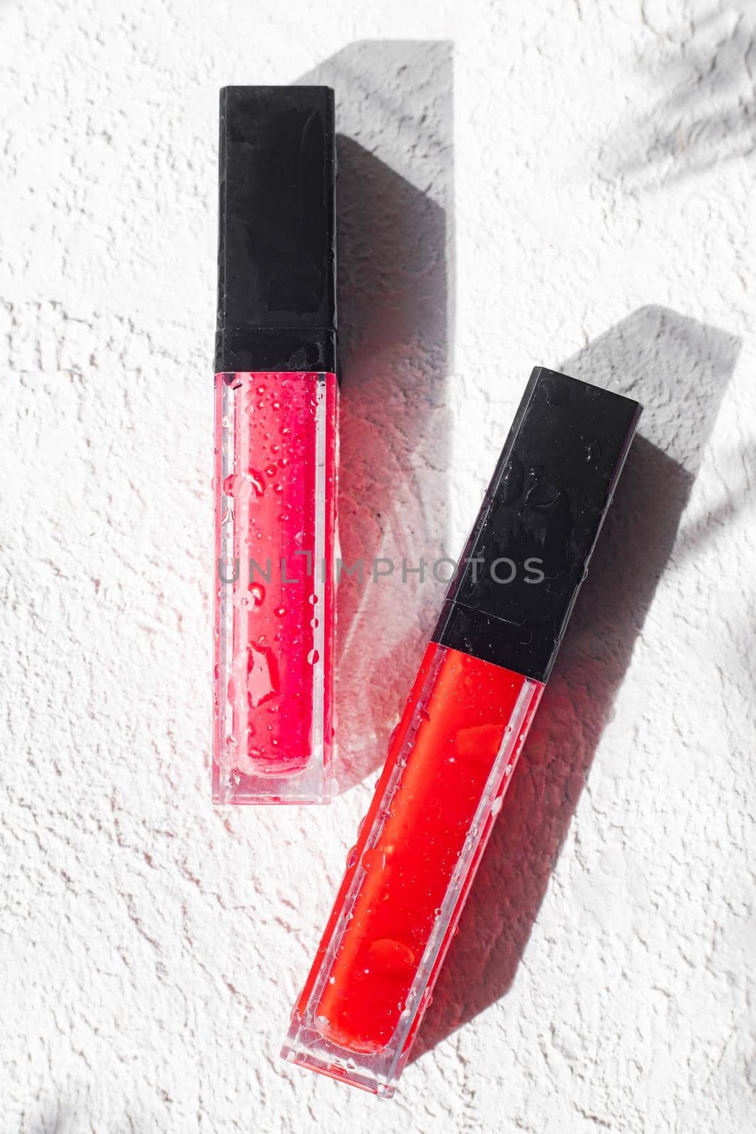 Lip gloss and sun shadow . The concept of lip gloss without labels. Decorative cosmetics. Lip care. Copy space