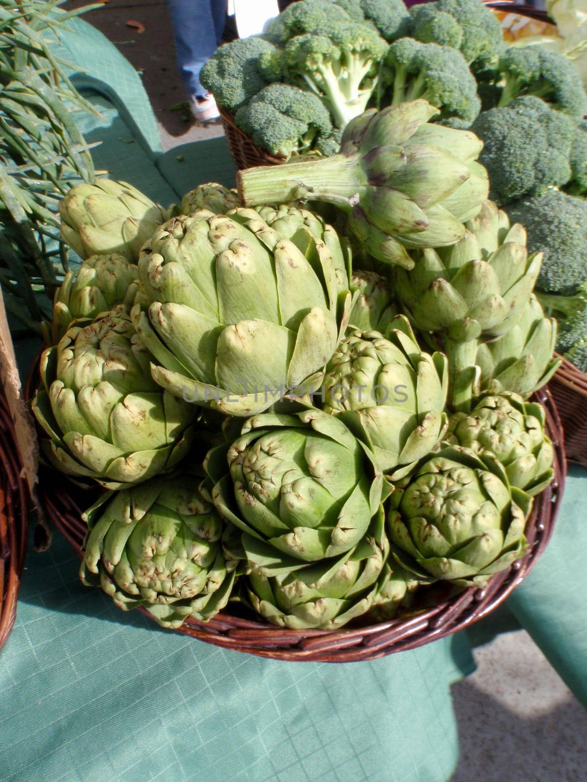 Pile of Artichoke and broccoli in baskets on display by EricGBVD