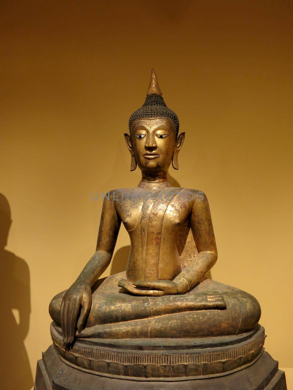 HonoluIu - May 9, 2015: Seated Buddha, 16th century, Artist is Anonymous, Medium Gilt bronze, inlaid shell and black lacquer, Geography: Thailand.  Displayed at Honolulu Museum of Art.