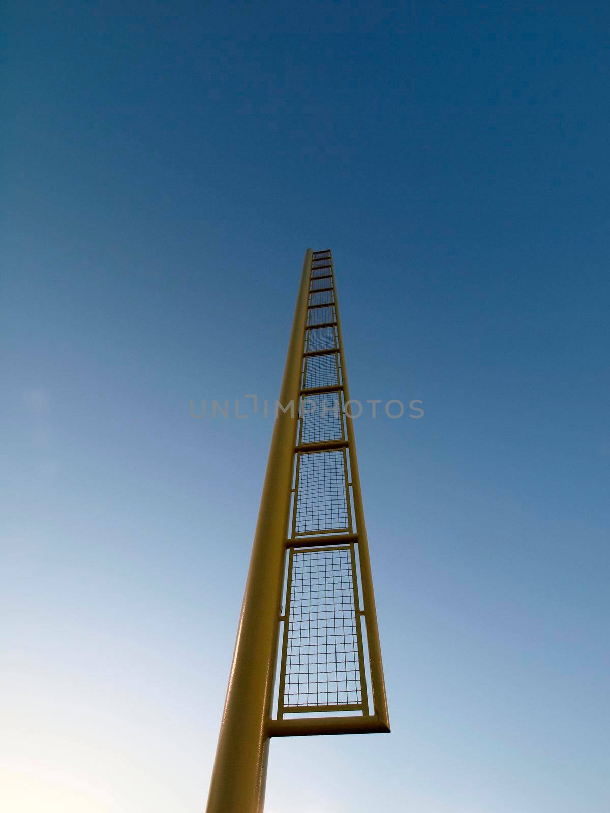 Yellow Baseball Foul Pole against blue sky.