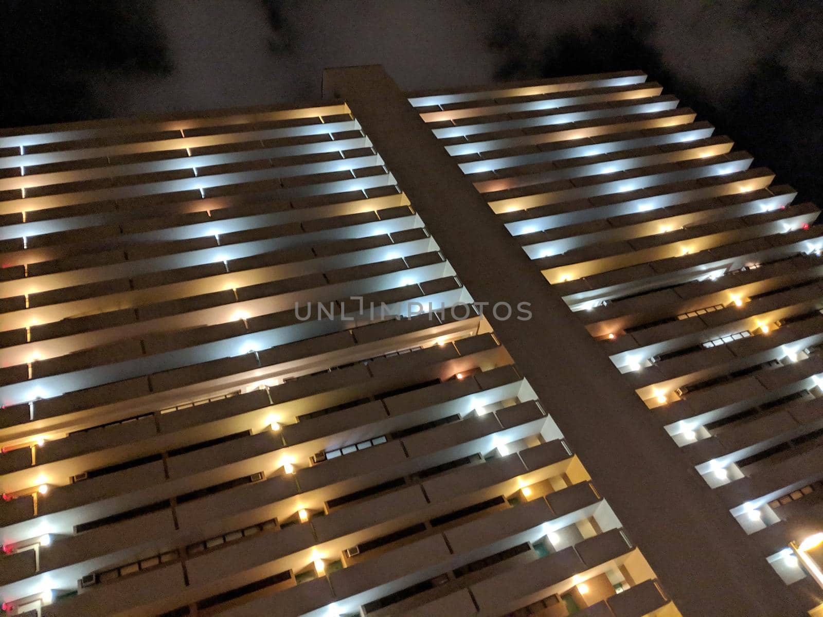 Honolulu - October 24, 2018: Looking up a Condo Building with outdoor hallway at Night.