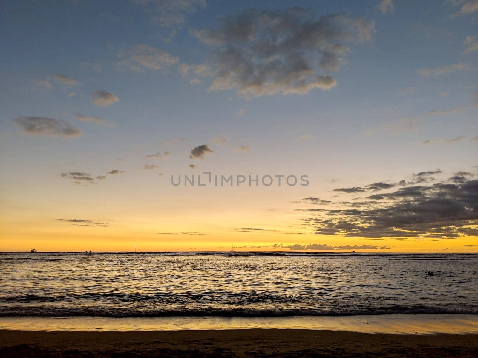 Dusk light reflecting on the Pacific ocean on the water with boats on the water off the beach of Waikiki\ by EricGBVD