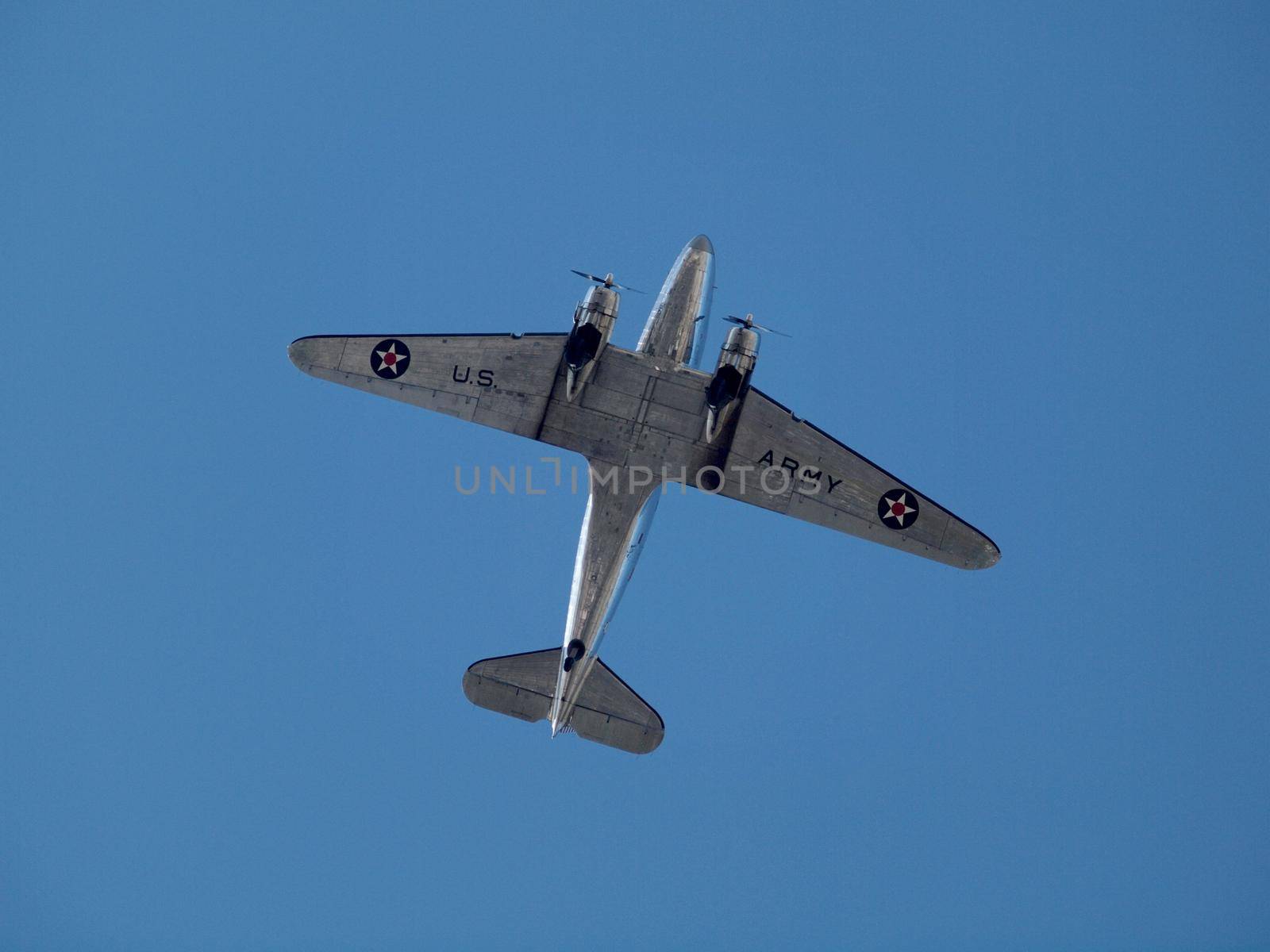 US Army Propeller plane flies overhead against a blue sky in USA.