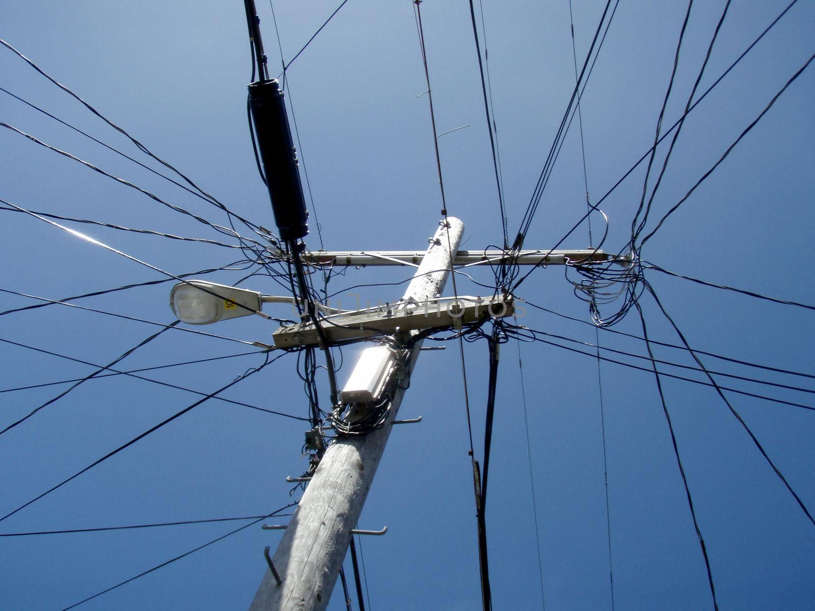 High Voltage Power Lines intersect at a wooden Utility pole in San Francisco, California.